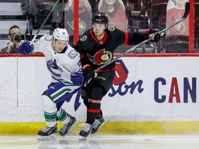 Ottawa Senators centre Josh Norris (right) checks Vancouver Canucks centre Matthew Highmore during third period NHL action at the Canadian Tire Centre, April 26, 2021.