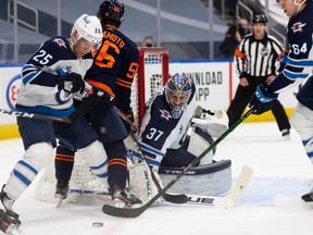 Winnipeg Jets goaltender Connor Hellebuyck (37) makes a save on the Edmonton Oilers during Game 2 of their NHL North Division playoff series at Rogers Place in Edmonton on Friday, May 21, 2021.