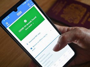 An illustration picture shows a smartphone screen displaying a Covid-19 vaccine record on the National Health Service (NHS) app in London, England, on May 18, 2021.