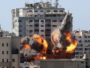 A ball of fire erupts from the Jala Tower as it is destroyed in an Israeli airstrike in Gaza city controlled by the Palestinian Hamas movement, on May 15, 2021.