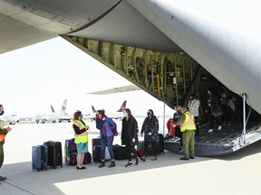 Physician Dr. Allison Furey, third right, the wife of Newfoundland and Labrador Premier Andrew Furey, along with military personnel and civilian doctors and nurses, arrive in a military Lockheed Martin C-130J Super Hercules turboprop military transport aircraft at Pearson International Airport on April 27, 2021.