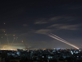 TOPSHOT - Israel's Iron Dome missile defence system (L) intercepts rockets (R) fired by the Hamas movement from Gaza city towards Israel early on May 16, 2021. - Israel pummelled the Gaza Strip with air strikes, killing 10 members of an extended family and demolishing a building housing international media outlets, as Palestinian militants fired back barrages of rockets. (Photo by MOHAMMED ABED / AFP) (Photo by MOHAMMED ABED/AFP via Getty Images)