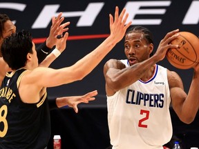 Former Raptors star Kawhi Leonard of the L.A. Clippers (right) looks to pass against the Raptors at Amalie Arena in Tampa, Fla., on May 11, 2021.