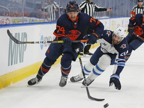 Edmonton Oilers defencemen Ethan Bear (74) and Winnipeg Jets defencemen Derek Forbort (24) chase a loose puck during their first-round Stanley Cup playoff series at Rogers Place on May 19, 2021.