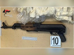 A Kalashnikov which was found in a fruit shop's storage room, where drugs and weapons were hidden, is seen in this screen grab taken from a video shot in Naples, Italy, May 6, 2021.