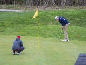 An unidentified golfer watches his putt as another man looks on Monday, April 26, 2021, at The Bridges at Tillsonburg. The course opened in defiance of the provincial stay-at-home order that closed golf courses and other outdoor recreation activities. (The London Free Press)