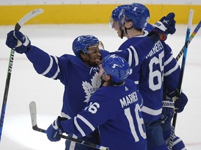 Maple Leafs forwards Wayne Simmonds (left) and Mitch Marner celebrate after defeating the Montreal Canadiens on Saturday night at Scotiabank Arena and clinching their first division title since 2000.