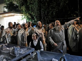 Ultra Orthodox Jewish men and children gather at the scene where a grandstand seating at a synagogue collapesed in the Israeli settlement of Givat Zeev in the occupied West Bank outside Jerusalem, on May 16, 2021.
