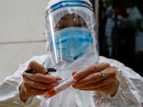 A health worker labels a test-sample tube during the coronavirus outbreak in Hanoi, Vietnam, January 29, 2021.