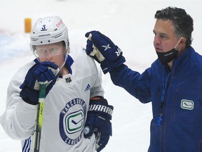 Rookie defenceman Jack Rathbone gets training-camp guidance from Canucks coach Travis Green.