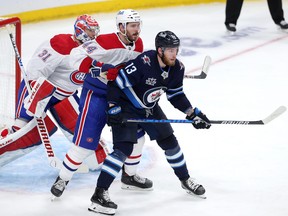Pierre-Luc Dubois of the Winnipeg Jets jockeys for space in front of Joel Edmundson and goalie Carey Price during Game 2.