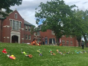 Flowers and tributes are left at the former Kamloops Indian Residential School on May 31, 2021 in Kamloops, B.C., in memory of the 215 children's bodies found on the site.