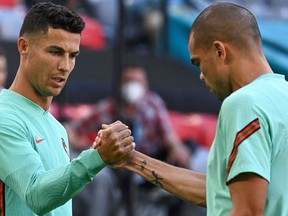 Portugal's forward Cristiano Ronaldo (L) and Portugal's defender Pepe take part in a training session at the Allianz Arena in Munich on June 18, 2021, on the eve of their UEFA EURO 2020 Group F football match against Germany.