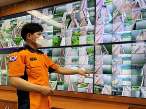 Head of Yeouido Water Rescue Brigade, Kim Hyeong-gil, monitors CCTV footage of bridges along the Han River in Seoul, South Korea, June 30, 2021.