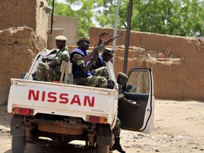 In this file photo taken June 27, 2012, Burkinabe soldiers patrol in a pick-up truck in Gorom-Gorom, northern Burkina Faso. Suspected jihadists have massacred more than 100 civilians in Burkina Faso's volatile north in the deadliest attacks since Islamist violence erupted in the west African country in 2015, officials said Saturday, June 5, 2021.