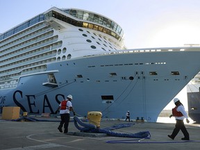 Dock workers use ropes to tie the Royal Caribbean’s Odyssey of The Seas to its berthing spot at Port Everglades on June 10, 2021 in Fort Lauderdale, Florida.