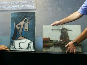 The paintings "Woman's Head" by Pablo Picasso and "Mill" by Piet Mondrian, both stolen from Greece's National Gallery in 2012, are displayed during a presentation to members of the media at the Ministry of Citizen Protection in Athens, Greece, Tuesday, June 29, 2021.