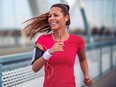 Positive beautiful female runner exercising outdoors on sunny summer morning.