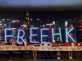 Pro-democracy protesters hold up a Free HK LED sign during a human chain from Tsim Sha Tsui to Prince Edward in Hong Kong, China, Sept. 30, 2019.