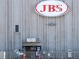 Employees walk around with face masks at the JBS USA meat packing plant in Greeley, Colorado, April 14, 2020.
