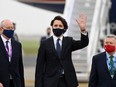 Prime Minister Justin Trudeau (centre), wearing a face covering due to COVID-19, waves after landing at Cornwall Airport Newquay, near Newquay, Cornwall, England, Thursday, June 10, 2021, ahead of the three-day G7 summit beginning Friday.