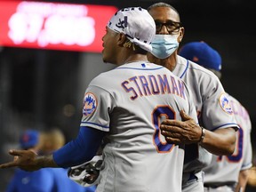 Marcus Stroman of the New York Mets is held back by bullpen coach Ricky Bones during an argument with the Arizona Diamondbacks during the sixth inning at Chase Field on June 1, 2021 in Phoenix, Ariz.