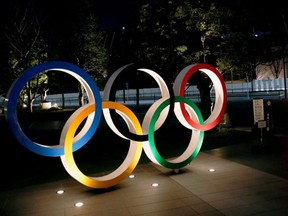 The Olympic rings are illuminated in front of the National Stadium in Tokyo, Jan. 22, 2021.