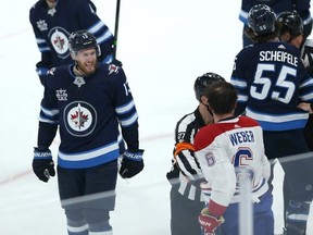 Winnipeg Jets centre Pierre-Luc Dubois (left) yells at Shea Weber as Montreal Canadiens defenceman looks for a piece of Jets centre Mark Scheifele during Game 1 of their division final.