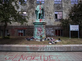 A statue of Egerton Ryerson is covered in paint and graffiti with shoes left at the base at Ryerson University in downtown Toronto on Tuesday, June 1, 2021.