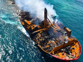This handout photograph taken and released by Sri Lanka Air Force on June 2, 2021 shows smoke billowing from the Singapore-registered container ship MV X-Press Pearl which carrys hundreds of containers of chemicals and plastics, as its towed away from the coast of Colombo, following Sri Lankan President Gotabaya Rajapaksa's order to move the ship to deeper water to prevent a bigger enviromental disaster.