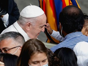 Pope Francis reacts as a child greets him upon his arrival for the weekly general audience at the San Damaso courtyard, amid the coronavirus disease (COVID-19) pandemic, at the Vatican, June 2, 2021.