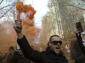 A protester waves a flare during a World Wide rally for freedom on July 24, 2021 in Melbourne, Australia.