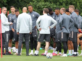 Stefan Kuntz, left, head coach of the German Olympic football team, talks with his players during a training session in Frankfurt am Main, western Germany, on July 13, 2021.