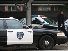 An Oakland Police officer walks by patrol cars at the Oakland Police headquarters on December 6, 2012 in Oakland, California.