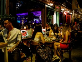 People sit at a bar, amid the spread of COVID-19, in Athens, Greece, July 6, 2021.