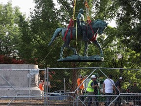 Workers remove a statue of Confederate General Robert E. Lee, after years of a legal battle over the contentious monument, in Charlottesville, Virginia, the U.S, July 10, 2021.