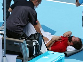 Russia's Daniil Medvedev is assisted by a physio during Tokyo 2020 Olympic Games men's singles third round tennis match.