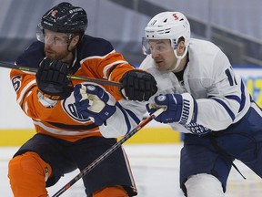 The Edmonton Oilers defence man Adam Larsson (6) battles the Toronto Maple Leafs' Zach Hyman (11) during second period NHL action at Rogers Place, in Edmonton Saturday Feb. 27, 2021.