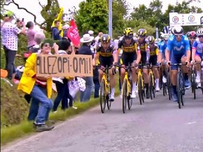A female spectator holding a large cardboard sign caused a massive pileup at the Tour de France last Saturday.
