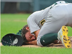 Starting pitcher Chris Bassitt #40 of the Oakland Athletics lies on the ground after being hit in the head by a line drive from Brian Goodwin of the Chicago White Sox in the second inning at Guaranteed Rate Field on August 17, 2021 in Chicago, Illinois.