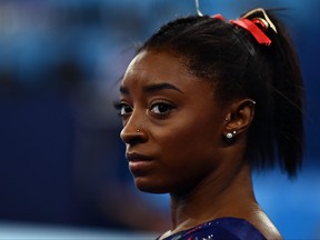 In this file photo taken on July 25, 2021 USA's Simone Biles gets ready to compete in the uneven bars event of the  artistic gymnastics women's qualification during the Tokyo 2020 Olympic Games at the Ariake Gymnastics Centre in Tokyo on July 25, 2021.