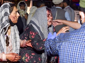 Wounded women arrive at a hospital for treatment after two blasts outside the airport in Kabul on Aug. 26, 2021.
