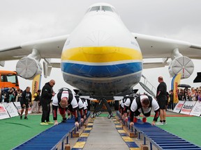Ukrainian strongman athletes attempt to set a world record for pulling the world's largest cargo plane Antonov An-225 Mriya at an airfield in the settlement of Hostomel outside Kyiv, Ukraine Aug. 26, 2021.