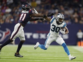 Chuba Hubbard of the Carolina Panthers tries to hold off the tackle of Zach Cunningham of the Houston Texans last week.