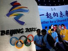 Attendees walk past a logo of the Beijing 2022 Winter Olympic Games following a ceremony in Beijing, Sept. 17, 2021.