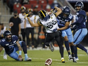 Argonauts defensive back Jeff Richards (23) separates Tiger-Cats wide receiver Jaelon Acklin from the football in the first half of their CFL game in Toronto, Friday, Sept. 10, 2021.