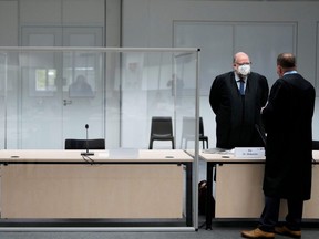 Two lawmakers stand next to the empty seat of the accused 96-year-old former secretary to the SS commander of the Stutthof concentration camp, at the Landgericht Itzehoe court, before a trial against her, in Itzehoe, Germany, Thursday, Sept. 30, 2021.