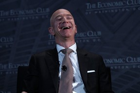 Jeff Bezos laughs as he participates in a discussion during a Milestone Celebration dinner September 13, 2018 in Washington, DC.