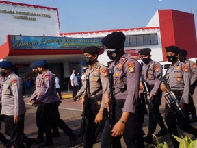 Indonesian police patrol at a prison in Tangerang after a fire broke out and killed dozens of inmates, Wednesday, Sept. 8, 2021.