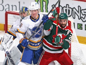 Rasmus Dahlin of the Buffalo Sabres moves Kyle Palmieri of the New Jersey Devils from the crease at the Prudential Center on March 16, 2021 in Newark, New Jersey.